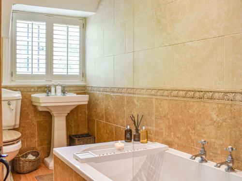 La salle de bains est pourvue d'une baignoire, d'un lavabo et de toilettes. dans l'établissement Greenbank Cottage, à Burley