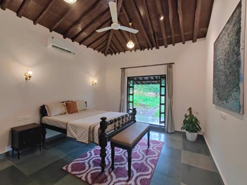 a bedroom with a bed and a ceiling fan at SaffronStays Mango Huts by the River, Pali in Jambhulpāda