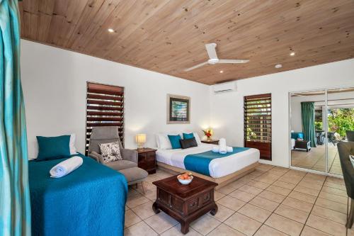 a bedroom with two beds and a couch and a chair at Mission Beach Shores in Mission Beach