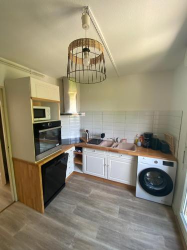 une cuisine avec un évier et un lave-vaisselle dans l'établissement Appartement 3p, 72m2, centre ville, parking privé tout confort, à Biscarrosse
