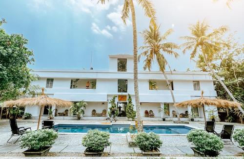 een hotel met een zwembad en palmbomen bij Satta Beach Residence in Varkala