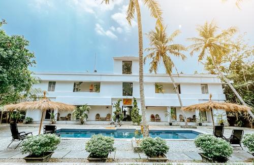 a hotel with a swimming pool and palm trees at Satta Beach Residence in Varkala