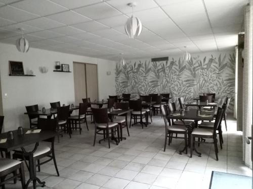 a dining room with tables and chairs and a mural at Du coq à l'âne in LʼAbsie