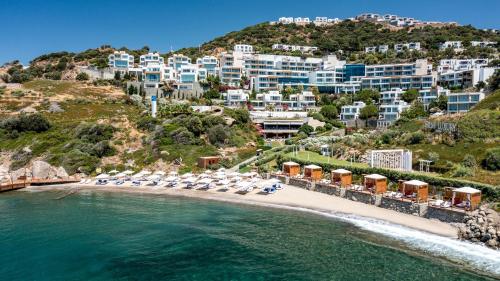 an aerial view of a beach with chairs and buildings at Sirene Luxury Hotel Bodrum in Yalıkavak