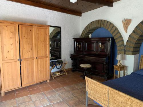 a bedroom with a bed and a desk and a piano at Cactus b&b Le casette di Marilena in Pantelleria