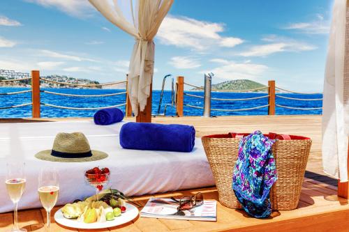 a bed on the deck of a boat with wine glasses at Sirene Luxury Hotel Bodrum in Yalıkavak