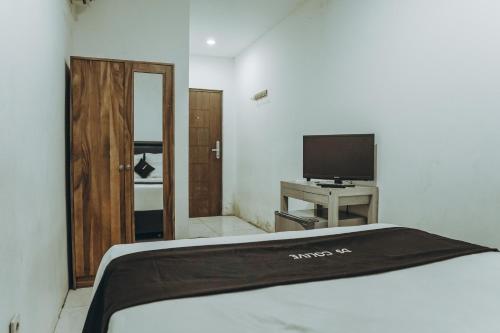 a bedroom with a bed and a flat screen tv at DS Colive Siliwangi in Kalibanteng-lor