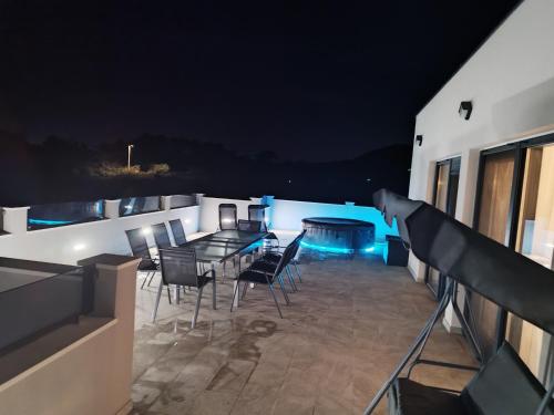 a view of a balcony at night with a table and chairs at Villa Infinity in Kastel Novi