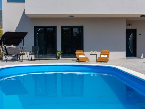 a large blue swimming pool in front of a house at Villa Infinity in Kastel Novi