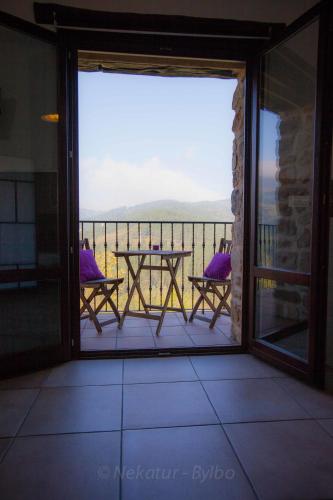 a patio with a table and chairs on a balcony at Gorosarri in Escoriaza