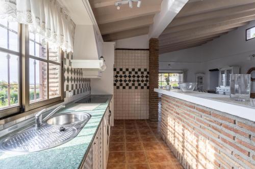 Un baño con lavabo y una gran ventana. en Villa Damian, en Málaga