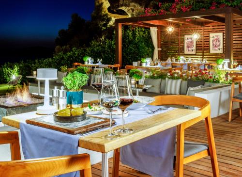 a table with glasses of wine on a patio at Sirene Luxury Hotel Bodrum in Yalıkavak