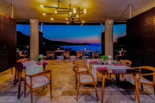 a restaurant with tables and chairs and a view of the ocean at Sirene Luxury Hotel Bodrum in Yalıkavak