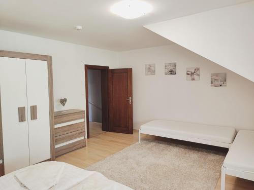 a white bedroom with a bed and a closet at Apartments Tatra Olla - Tatranská Lomnica in Tatranská Lomnica