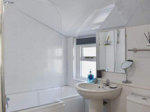 a white bathroom with a sink and a mirror at 1 Hamilton Terrace in Lamlash