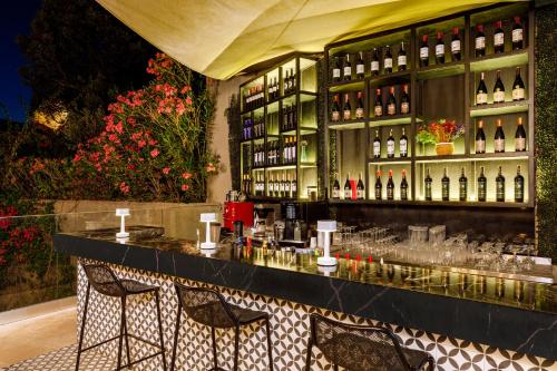 a bar with two chairs and bottles of wine at Sirene Luxury Hotel Bodrum in Yalıkavak