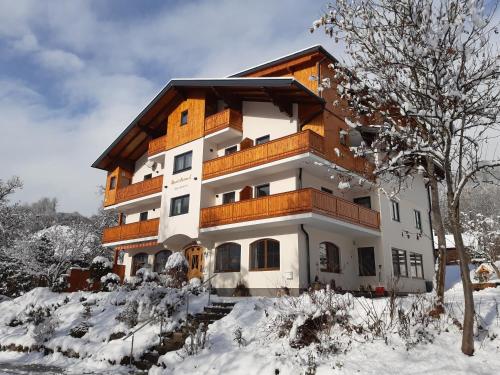 a building with snow on the ground in front of it at Unser Hoamat Appartement in Schladming