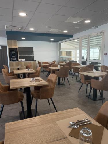 a dining room with tables and chairs in a cafeteria at Campanile Montpellier Ouest - Croix D'Argent in Montpellier