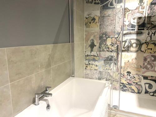 a bathroom with a bathtub, sink, and mirror at Boho Beach House - Beach location in Bournemouth