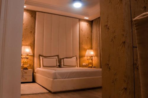 a bedroom with a bed with two lamps on it at Royal 9 hotel & Banquet in Meerut