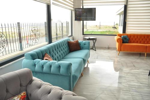 a blue couch in a living room with windows at Yalıköy Deniz Otel Istanbul in Yalıköy