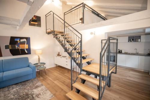 a spiral staircase in a living room with a blue couch at Grand Hotel Duchi d'Aosta Apartments in Trieste