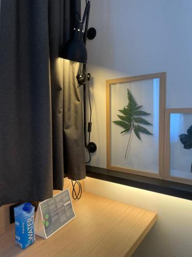 a desk with a lamp and a picture of a tree at Campanile Montpellier Ouest - Croix D'Argent in Montpellier