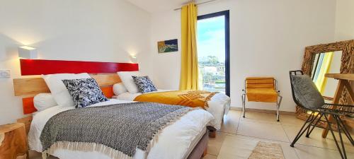a bedroom with two beds and a mirror and a window at VILLA ROCCA BRUNA, LE CAP CORSE 5 ETOILES in Santa-Maria-di-Lota