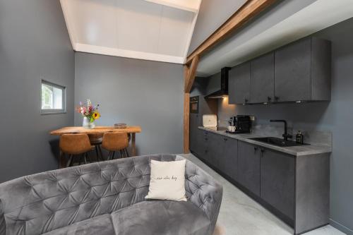 a living room with a couch and a kitchen at Vrijstaand huisje, dichtbij Kinderdijk in Oud-Alblas