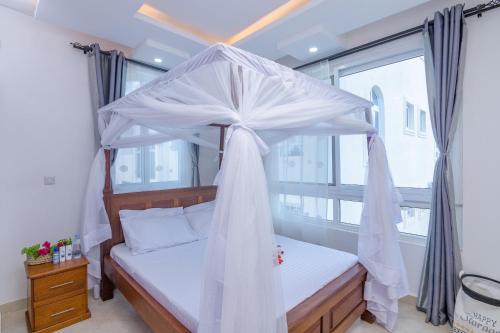 sypialnia z łóżkiem z baldachimem i oknem w obiekcie Cozy Crib w mieście Malindi