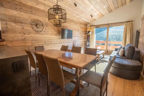 une salle à manger avec une table, des chaises et un canapé dans l'établissement Sherpa 17 with sauna - Mottaret's snowfront, à Méribel