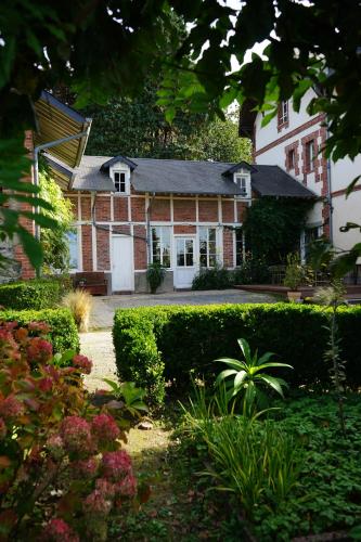 una casa con un jardín delante de ella en La Villégiature en Coutances
