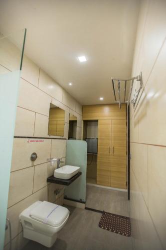a bathroom with a toilet and a sink and a shower at Hotel Fun City in Navsāri