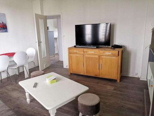 a living room with a tv and a white table at apartment near the Breton coast 5 Location appartement près des côtes bretonnes in Saint-Brieuc