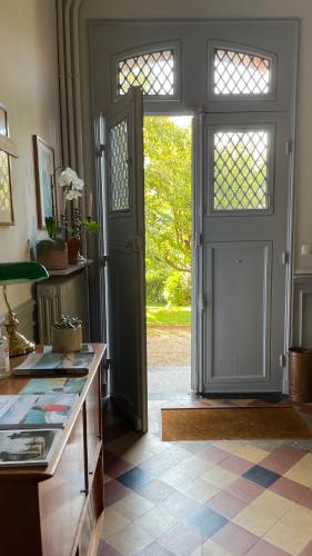 a room with an open door with a table and a table sidx sidx at La Villégiature in Coutances