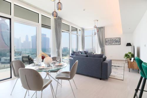 a living room with a couch and a table and chairs at HiGuests - Spacious Apt Near Zabeel Park With Panoramic Views in Dubai