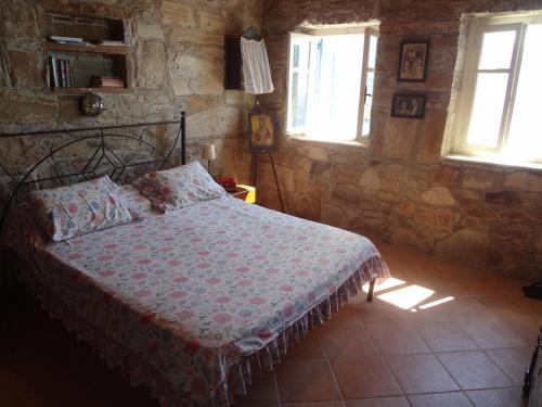 ein Schlafzimmer mit einem Bett in einer Steinmauer in der Unterkunft Luxurious Villa with Private Beach in Apróvaton