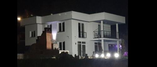 a large white house with a balcony at night at LUX Villa Mavrovo in Mavrovo