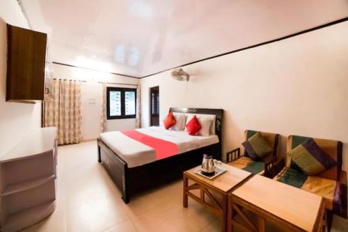 een hotelkamer met een bed en een bank bij Goroomgo Blue Moon Resort Lake View Mall Road Bhimtal - Best Seller in Nainital