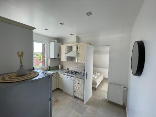 une cuisine avec des armoires blanches et un four à plaques de cuisson dans l'établissement Superbe T3 proche Paris & Disneyland, à Ozoir-la-Ferrière