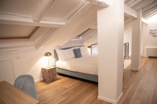 a bedroom with white walls and a bed and wooden floors at Grand Hotel Duchi d'Aosta Apartments in Trieste