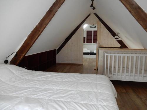 - une chambre mansardée avec un lit blanc dans l'établissement Holiday Home Cuylehoeve, à Leffinge