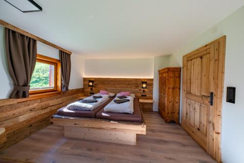 a bedroom with a bed and a wooden floor at Sonnentalhof in Itter