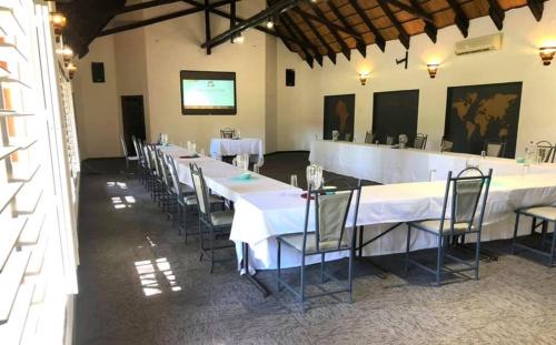 a group of tables and chairs in a room at Okahandja Country Hotel in Okahandja