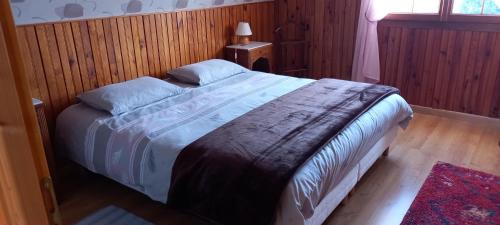 um quarto com uma cama com um cobertor em Gîte du Bel Air em Festigny