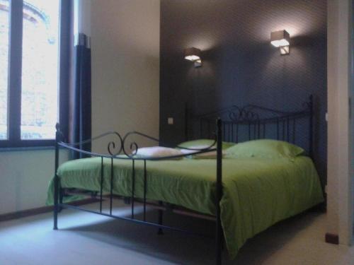sypialnia z czarnym łóżkiem z zieloną kołdrą w obiekcie LOGIES The city jester - Ieper centrum w mieście Ypres