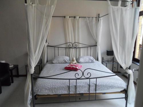 Schlafzimmer mit einem Metallbett und weißen Vorhängen in der Unterkunft LOGIES The city jester - Ieper centrum in Ypern