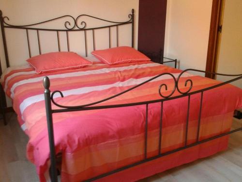 un letto con lenzuola rosse e arancioni e cuscini rossi di LOGIES The city jester - Ieper centrum a Ypres