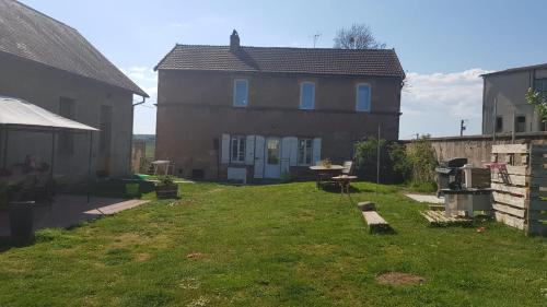 a backyard of a house with a grass yard at Les chambres de la tribu in Curgy