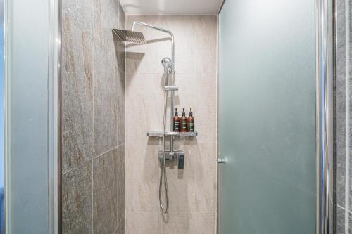 a shower in a bathroom with a glass door at Hotel With City in Jeju